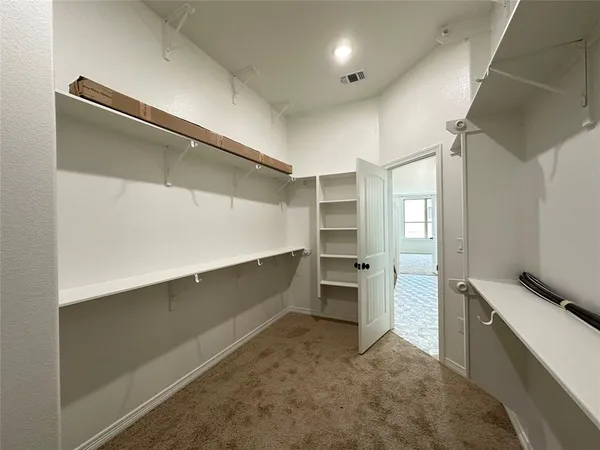 a view of walk in closet with empty racks