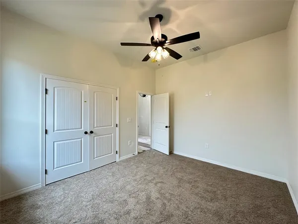 an empty room with closet and fan