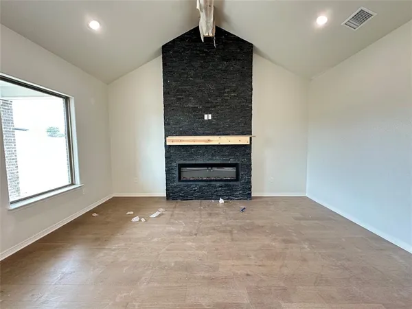 a view of an empty room with a fireplace and a window