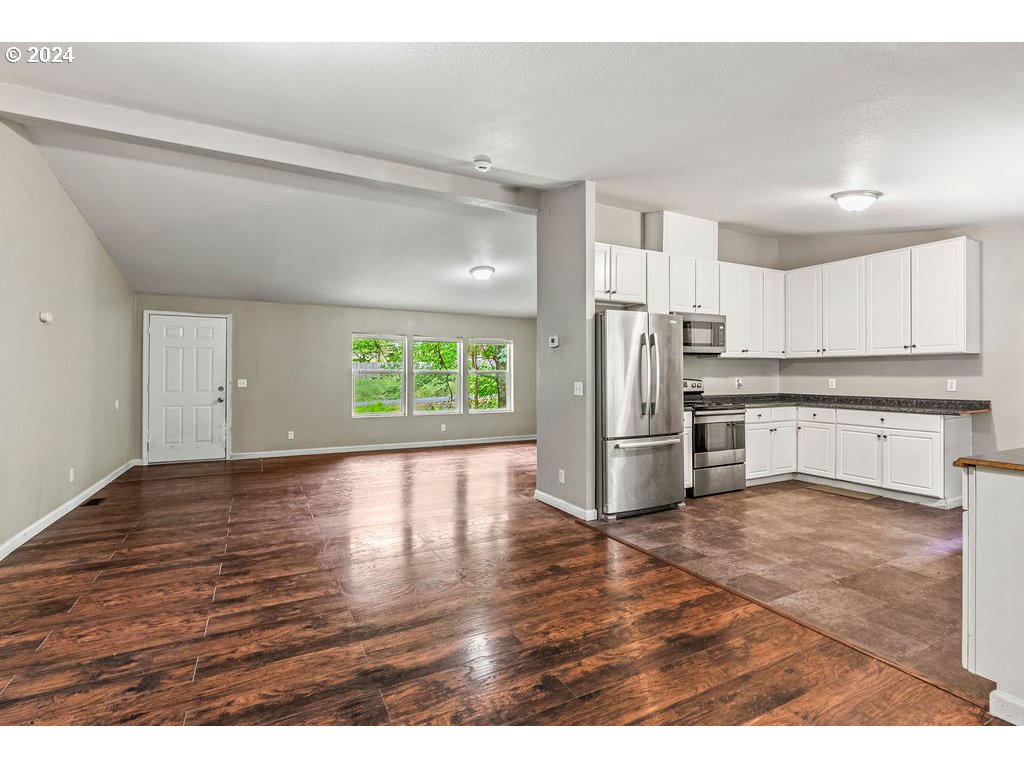 119 Ragland Road Longview, WA 98632 - Photo 11 of 30 a kitchen with stainless steel appliances granite countertop a refrigerator a stove top oven a sink and dishwasher with wooden floor