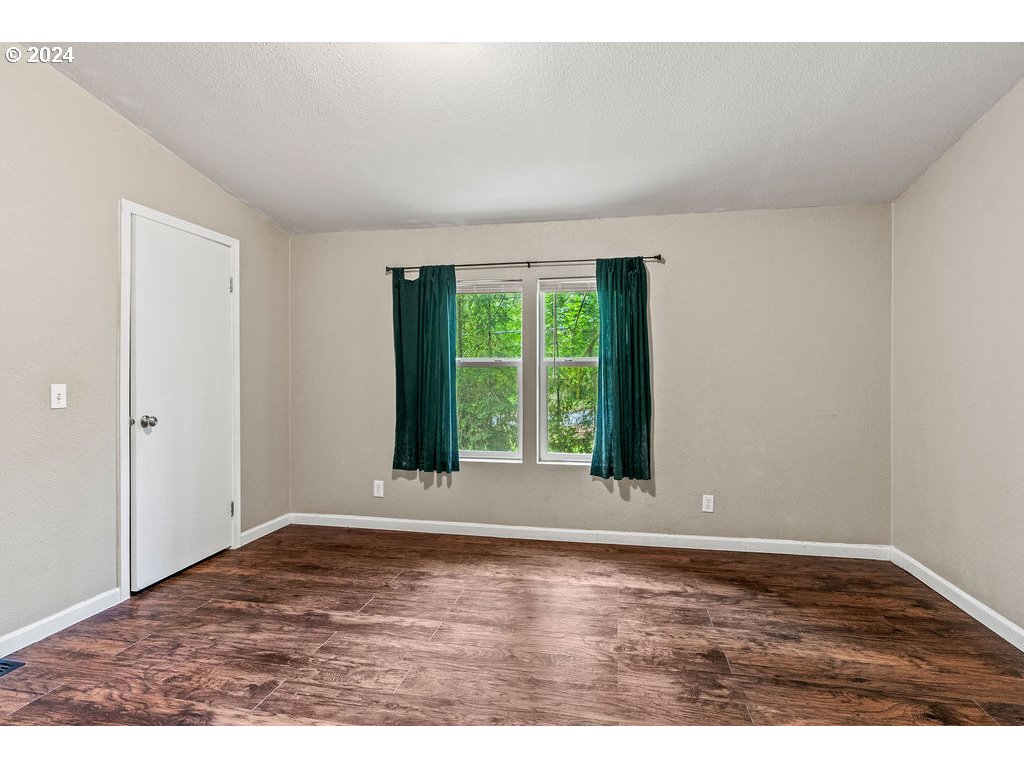 119 Ragland Road Longview, WA 98632 - Photo 13 of 30 a view of an empty room with wooden floor and a window