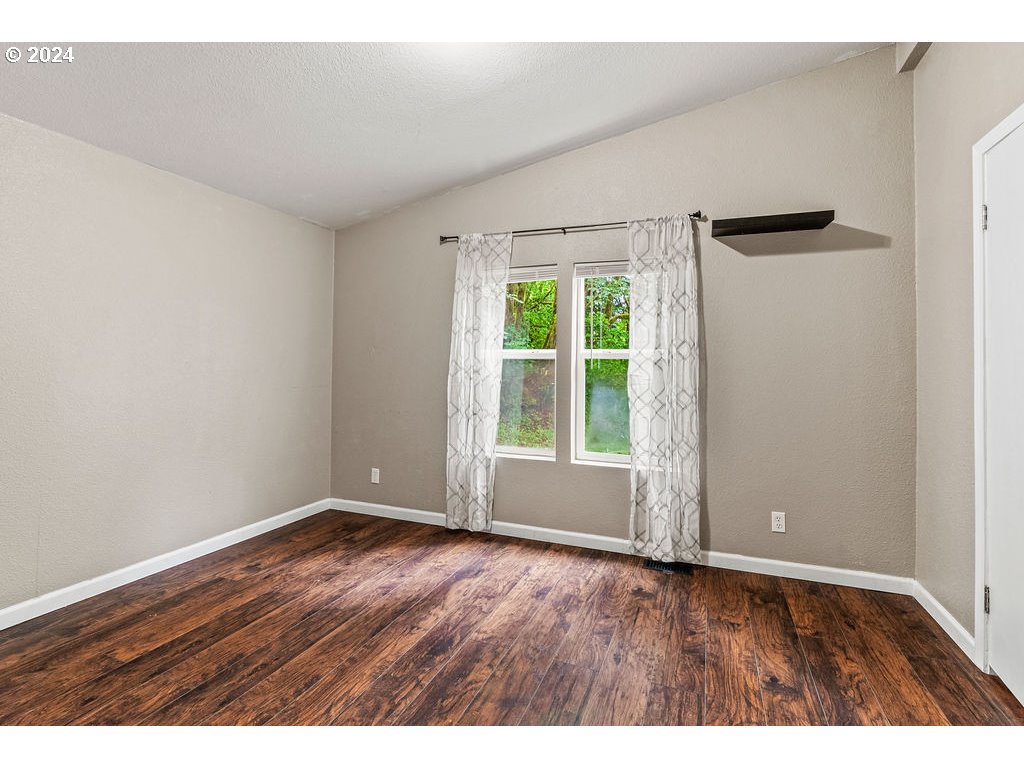 119 Ragland Road Longview, WA 98632 - Photo 14 of 30 a view of an empty room with wooden floor and a window