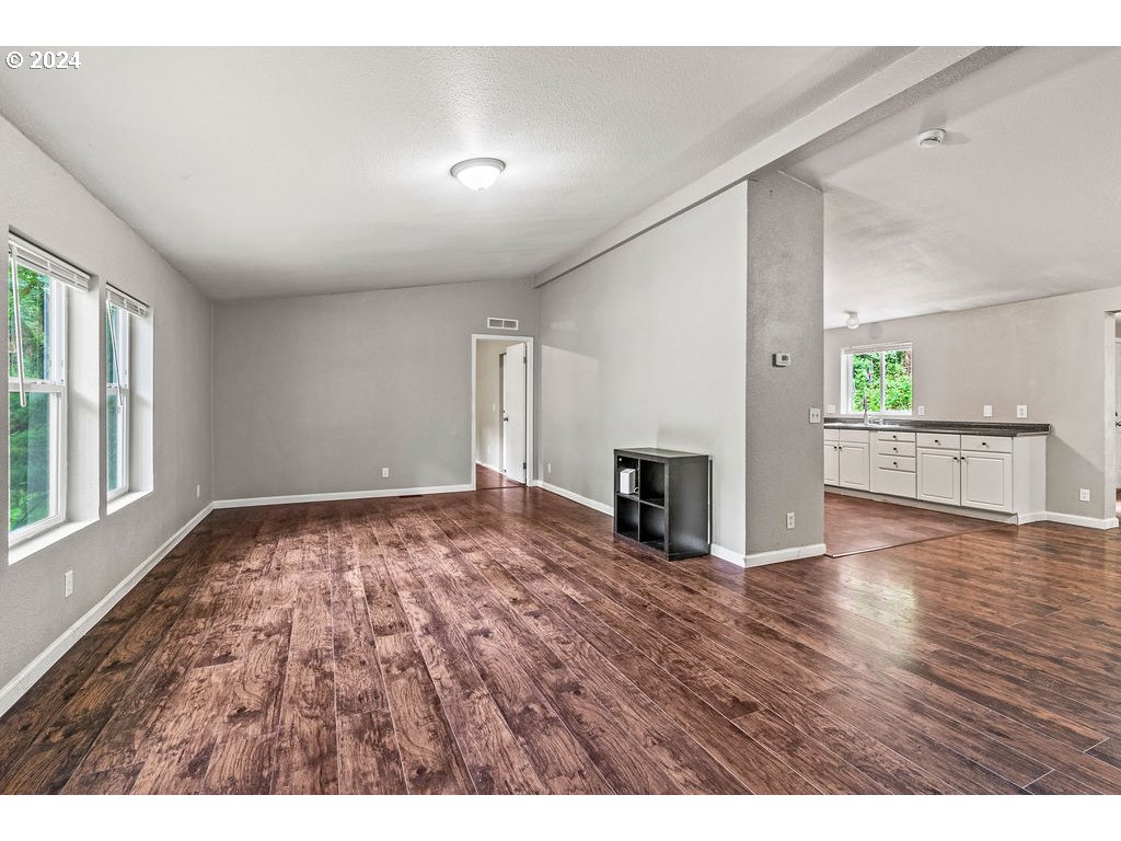 119 Ragland Road Longview, WA 98632 - Photo 3 of 30 a view of an empty room with window and wooden floor