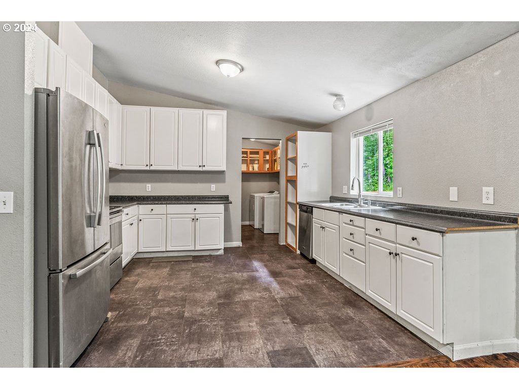 119 Ragland Road Longview, WA 98632 - Photo 6 of 30 a kitchen with granite countertop a refrigerator sink and cabinets
