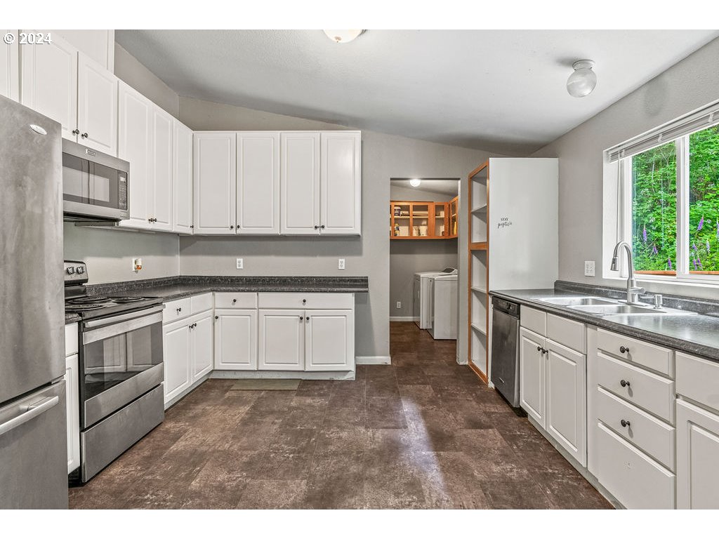 119 Ragland Road Longview, WA 98632 - Photo 7 of 30 a kitchen with granite countertop white cabinets and white appliances