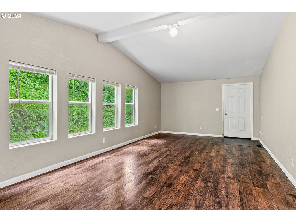 119 Ragland Road Longview, WA 98632 - Photo 9 of 30 an empty room with wooden floor and windows