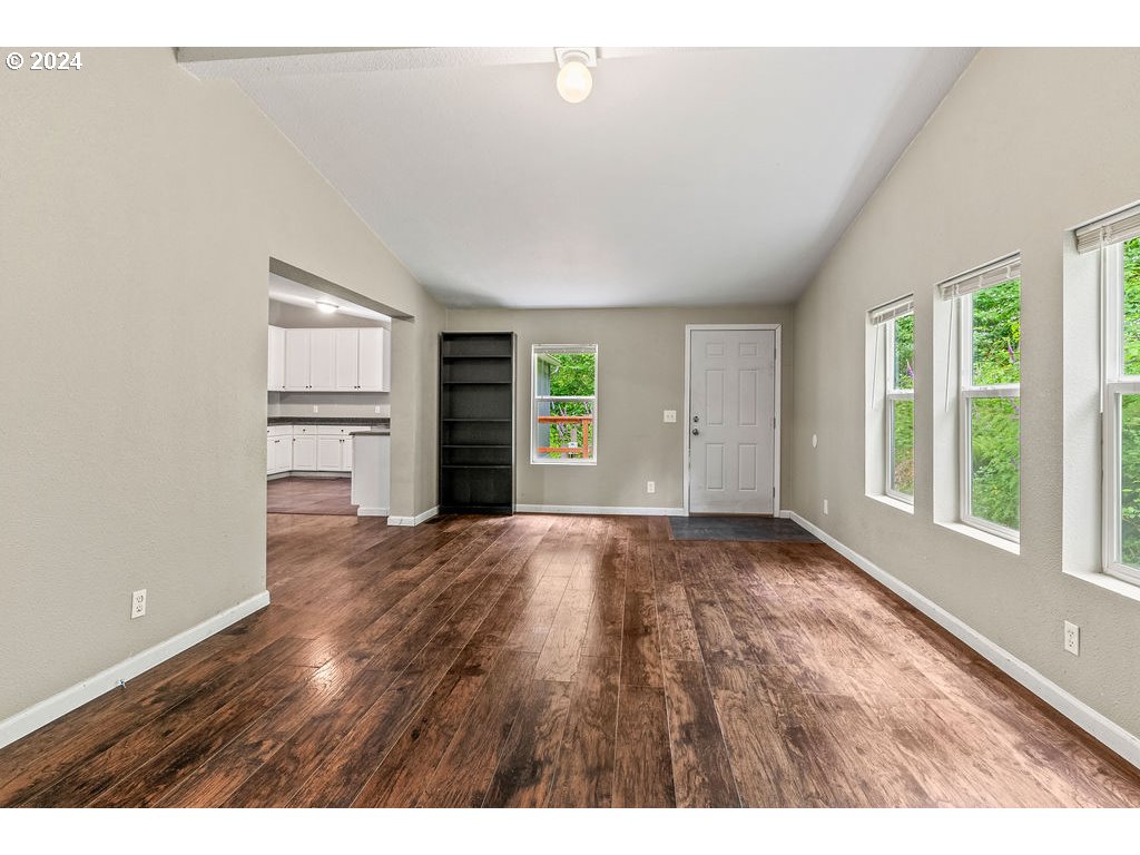 119 Ragland Road Longview, WA 98632 - Photo 10 of 30 a view of an empty room with a window and wooden floor
