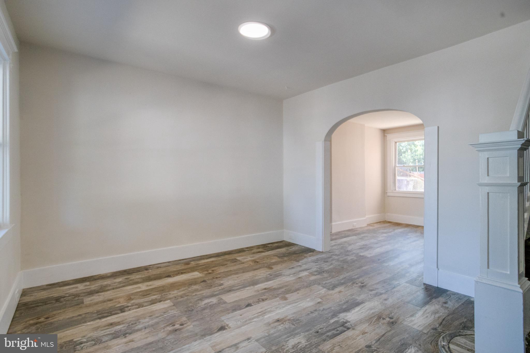 5878 Belair Road Baltimore, MD 21206 - Photo 4 of 41 an empty room with wooden floor and mirror