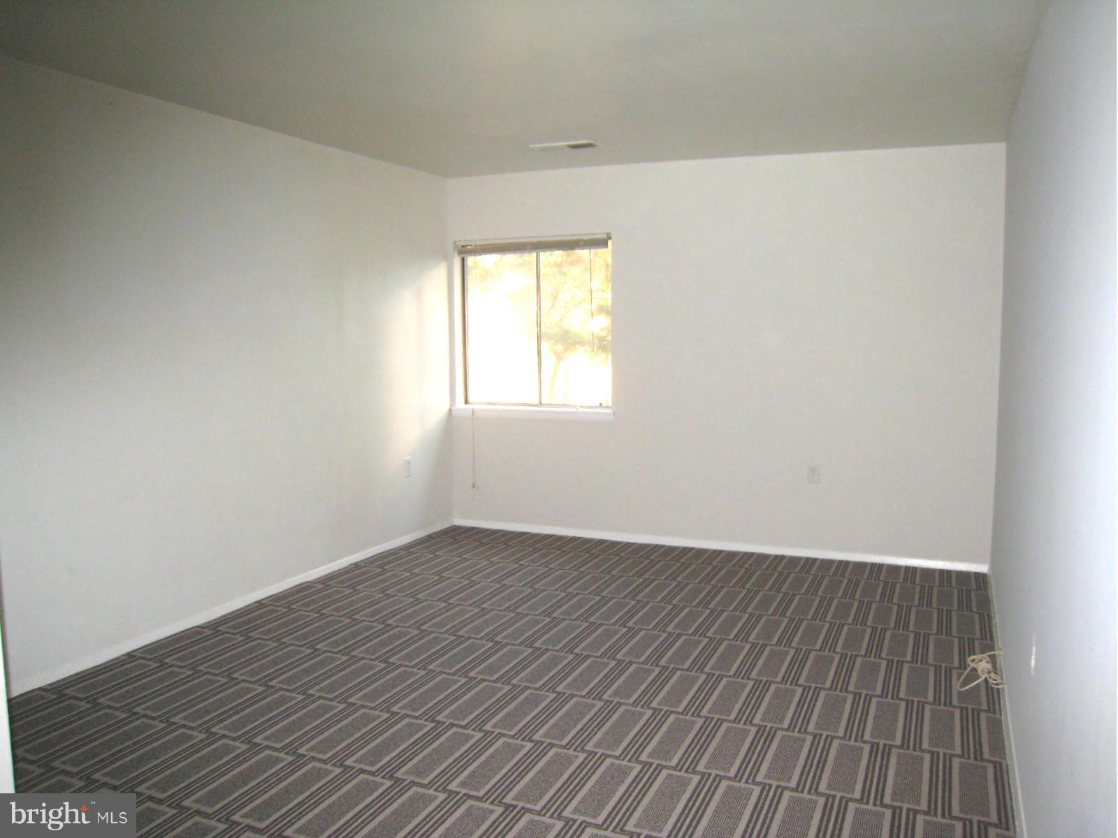 18610 Walkers Choice Road, Unit 4 Gaithersburg, MD 20886 - Photo 6 of 15 an empty room with wooden floor and windows