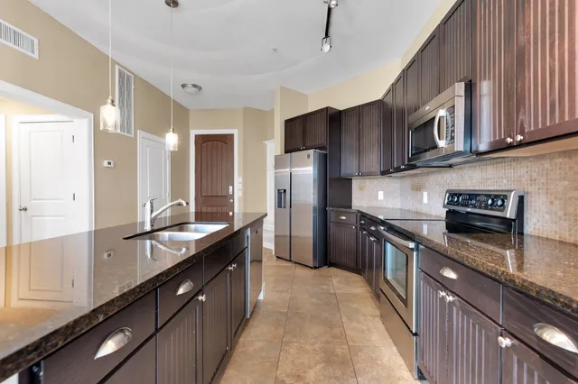 a kitchen with stainless steel appliances granite countertop a stove a sink dishwasher a refrigerator and a oven