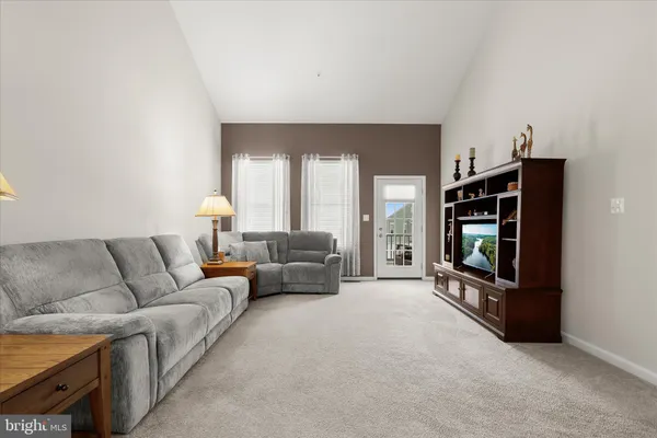 a bedroom with a bed a computer on desk and a dresser next to a window