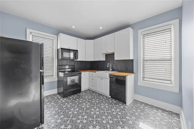 a kitchen with granite countertop a stove a sink and a refrigerator