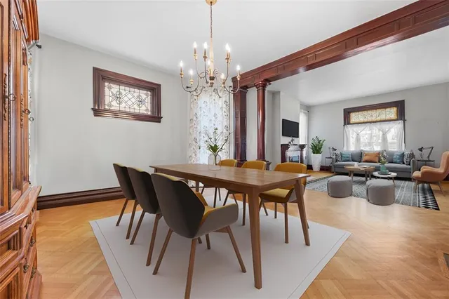a view of a dining room with furniture a chandelier and wooden floor