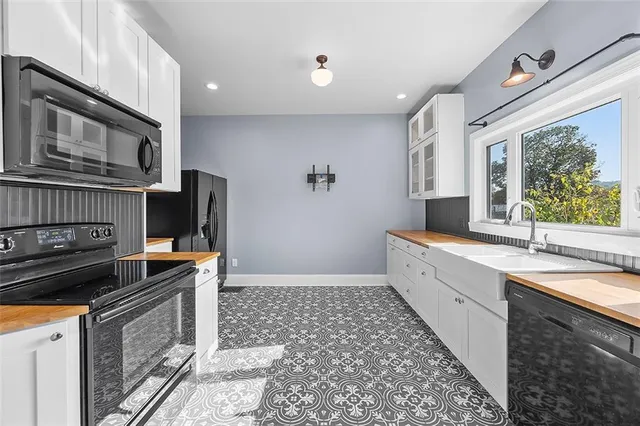 a kitchen with stainless steel appliances a stove microwave and sink