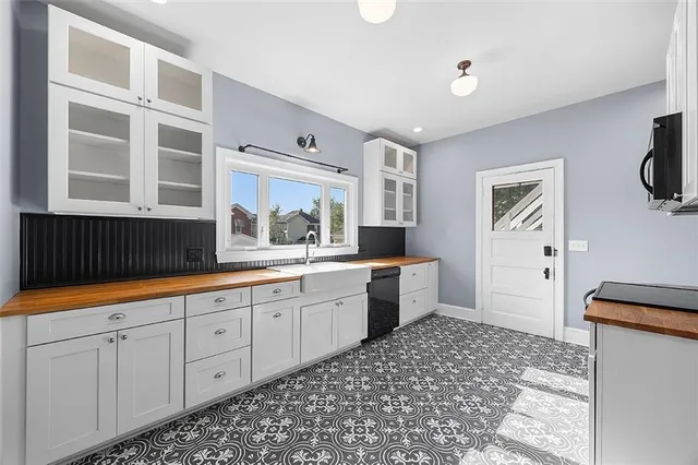 a large white kitchen with a sink and cabinets