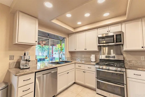 a kitchen with granite countertop a stove sink and cabinets