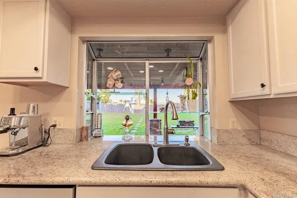 a bathroom with a granite countertop sink and window