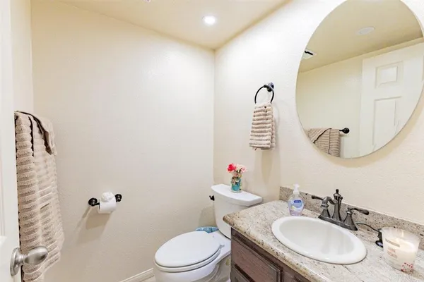 a bathroom with a sink vanity mirror and toilet