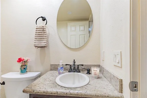 a bathroom with a granite countertop sink a mirror and a shower