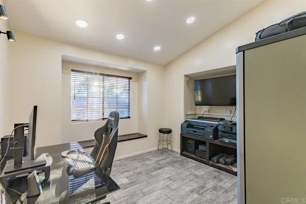 a view of a workspace with furniture and a flat screen tv