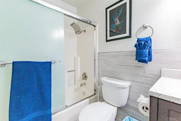 a white toilet sitting next to a bathroom sink and a mirror