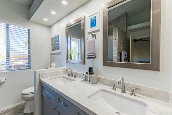 a bathroom with a granite countertop sink a toilet and a mirror