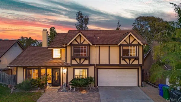 a front view of a house with a yard and trees