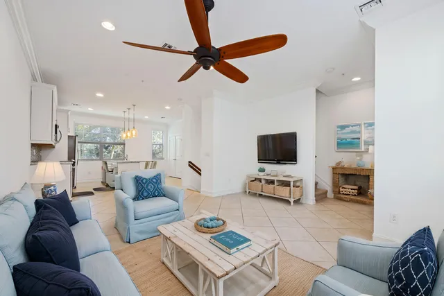 a living room with furniture and a flat screen tv with kitchen view