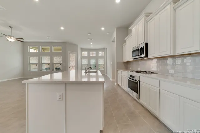 a kitchen with stainless steel appliances granite countertop refrigerator sink and stove