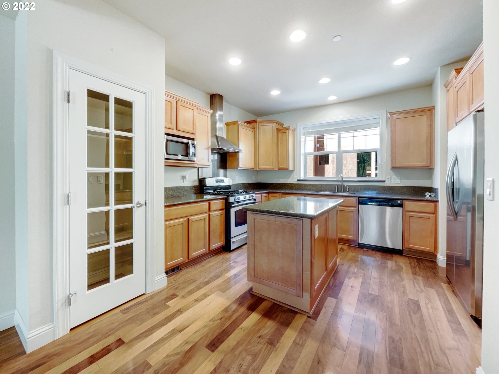 12111 Southeast High Creek Road Happy Valley, OR 97086 - Photo 4 of 14 a kitchen with stainless steel appliances granite countertop a stove a sink dishwasher a refrigerator and white cabinets with wooden floor