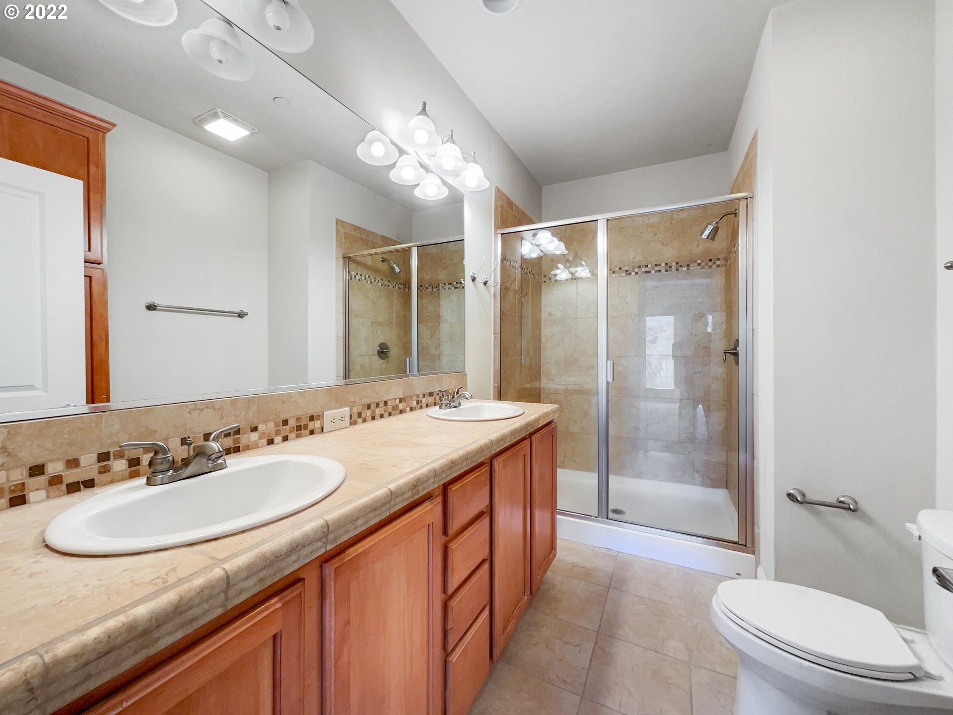 12111 Southeast High Creek Road Happy Valley, OR 97086 - Photo 9 of 14 a bathroom with a granite countertop sink a toilet a mirror and shower