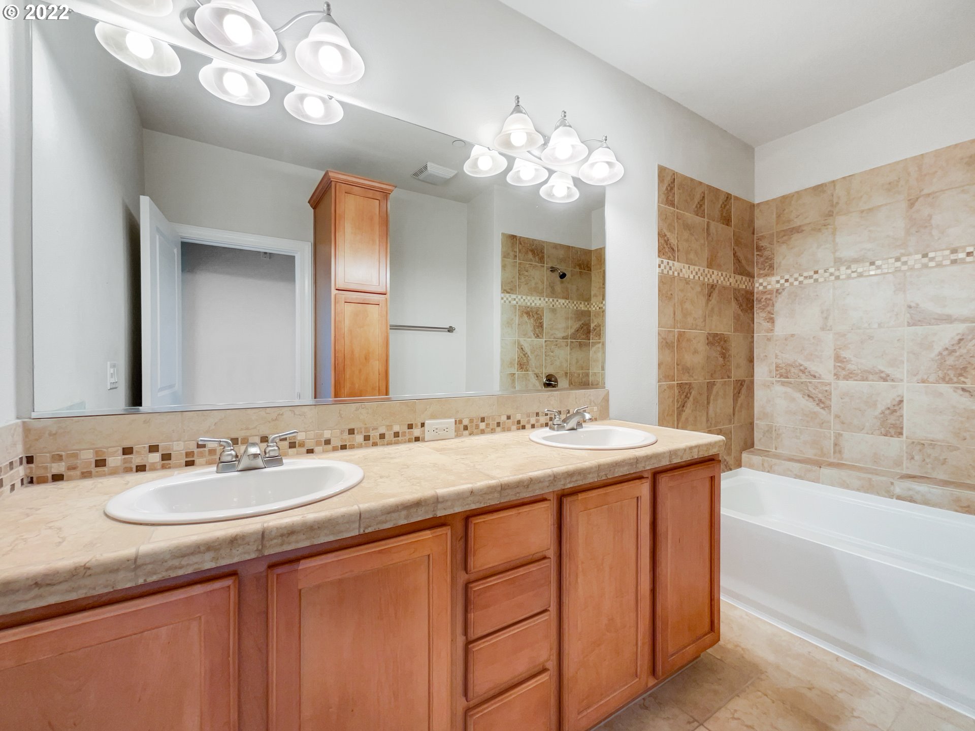 12111 Southeast High Creek Road Happy Valley, OR 97086 - Photo 10 of 14 a bathroom with a granite countertop sink a large mirror and a bathtub
