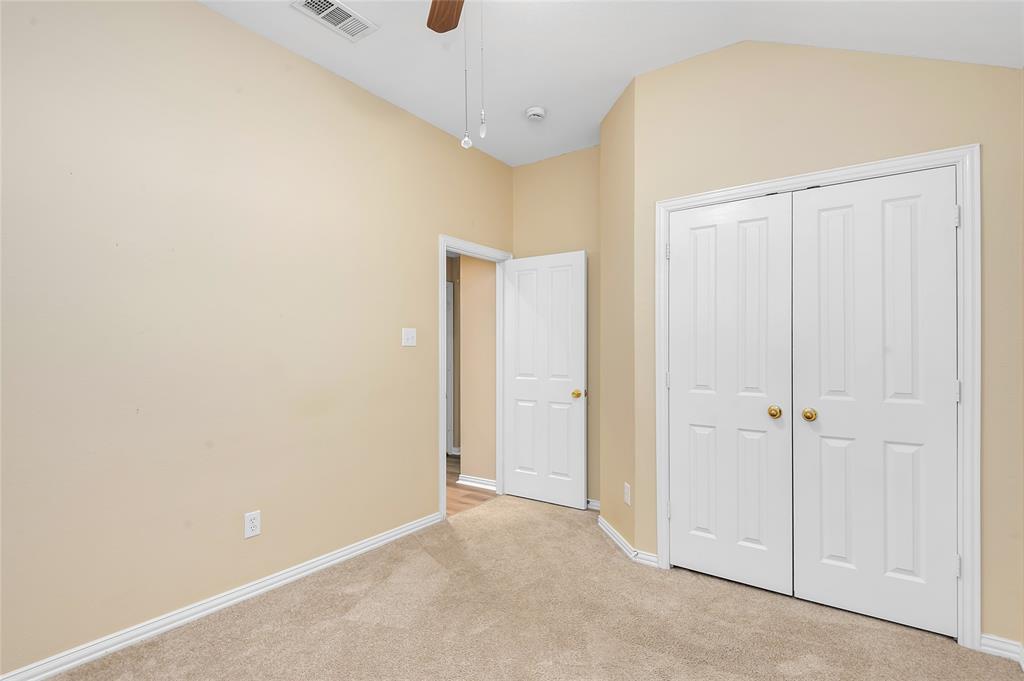 1404 Ranch Hill Drive Irving, TX 75063 - Photo 20 of 31 Carpeted room featuring a vaulted ceiling with a ceiling fan, a bi-fold closet with panel doors, and neutral wall tones