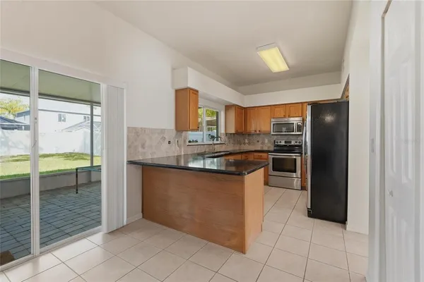 a kitchen with granite countertop a refrigerator and cabinets