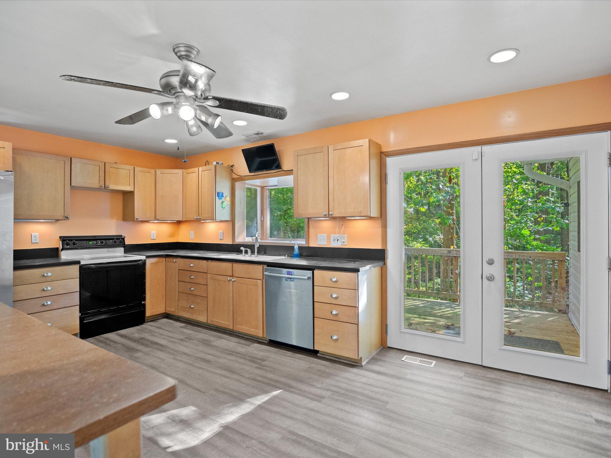 3671 Dory Brooks Road Chesapeake Beach, MD 20732 - Photo 13 of 36 a kitchen with stainless steel appliances granite countertop a stove top oven a sink with wooden floors and stainless steel appliances