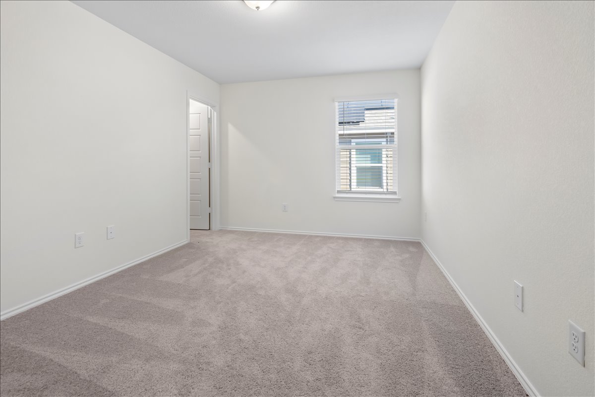 18501 Spotted Eagle Lane Elgin, TX 78621 - Photo 22 of 40 A spacious, naturally illuminated room offers a peaceful retreat with plush carpeting and a large window.