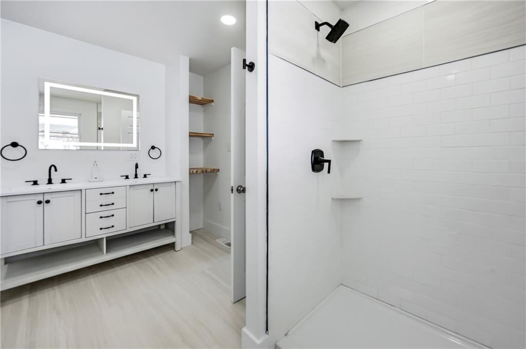 1480 George Street Hermitage, PA 16148 - Photo 20 of 40 a bathroom with a double vanity sink a mirror and a bathtub