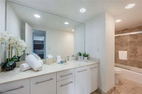 a bathroom with a granite countertop sink a mirror and a shower