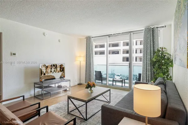 a living room with furniture and a floor to ceiling window