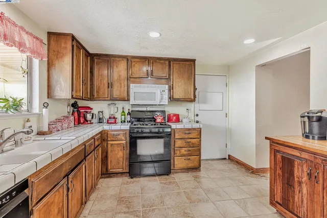 a kitchen with stainless steel appliances a sink stove and cabinets