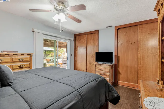 a bedroom with a bed and a flat tv screen on dresser