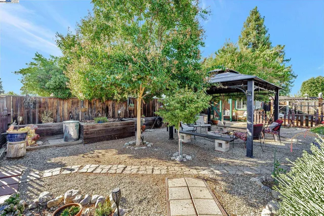 a view of a patio with table and chairs under an umbrella