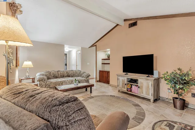 a spacious bedroom with a bed and a flat screen tv