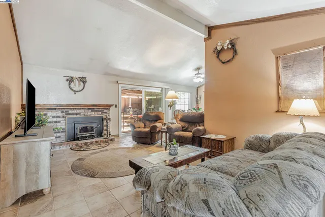a living room with furniture a fireplace and a flat screen tv