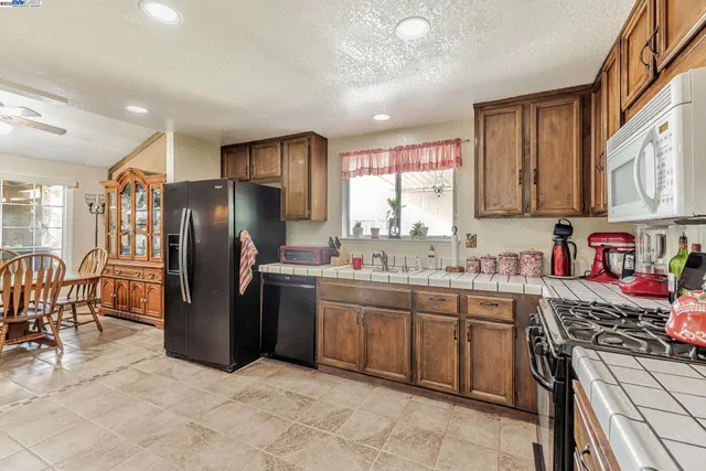 a kitchen with stainless steel appliances granite countertop a refrigerator and a stove top oven