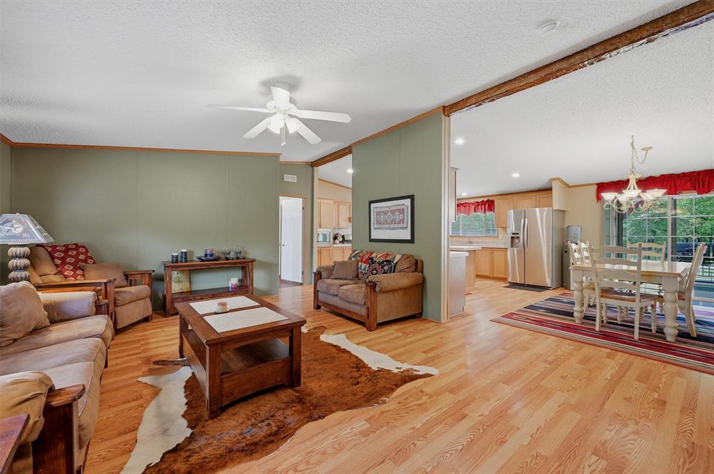 212 Sunset Road Pottsboro, TX 75076 - Photo 5 of 40 a living room with furniture a rug and a chandelier