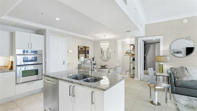 a kitchen with stainless steel appliances granite countertop a sink and a refrigerator