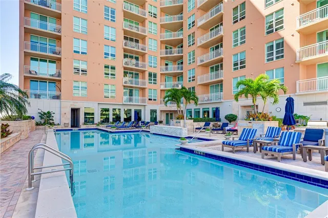 a view of a patio with couches table and chairs potted plants and palm tree
