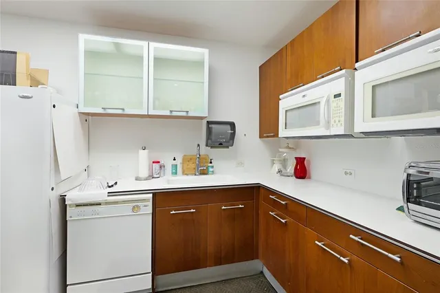 a view of a dining room with furniture a kitchen and wooden floor