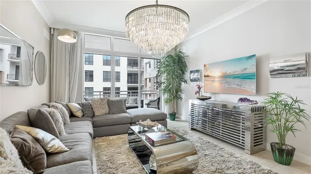 a living room with furniture chandelier and a large window
